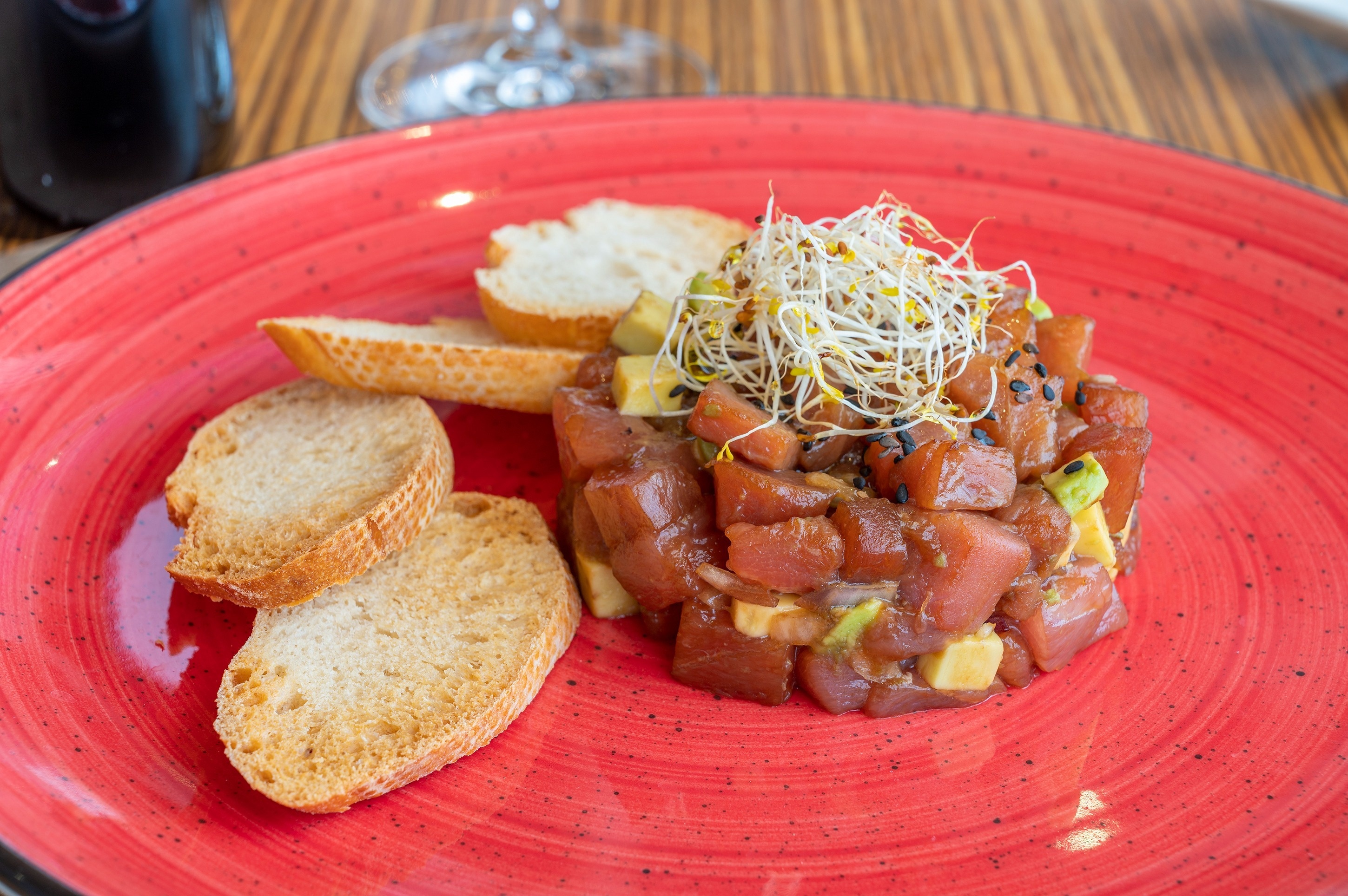 a red plate with a salad and bread on it