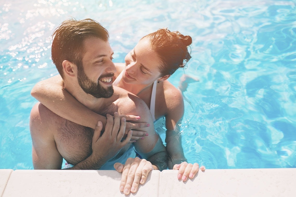 un hombre y una mujer se abrazan en una piscina