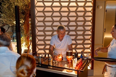 a woman in a white shirt is preparing a drink - 