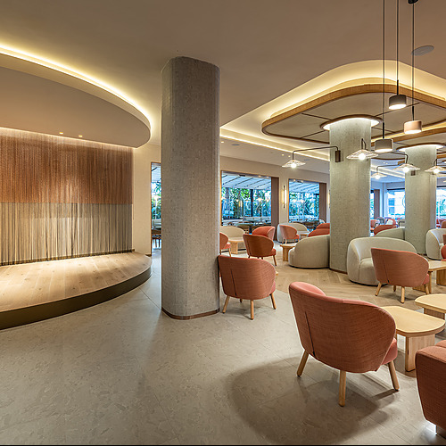 Lounge de hotel con sillones y mesas de madera, ideal para Port Hotels: Corporativa.