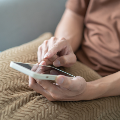 Una persona está usando un teléfono inteligente con ambas manos, tocando la pantalla.