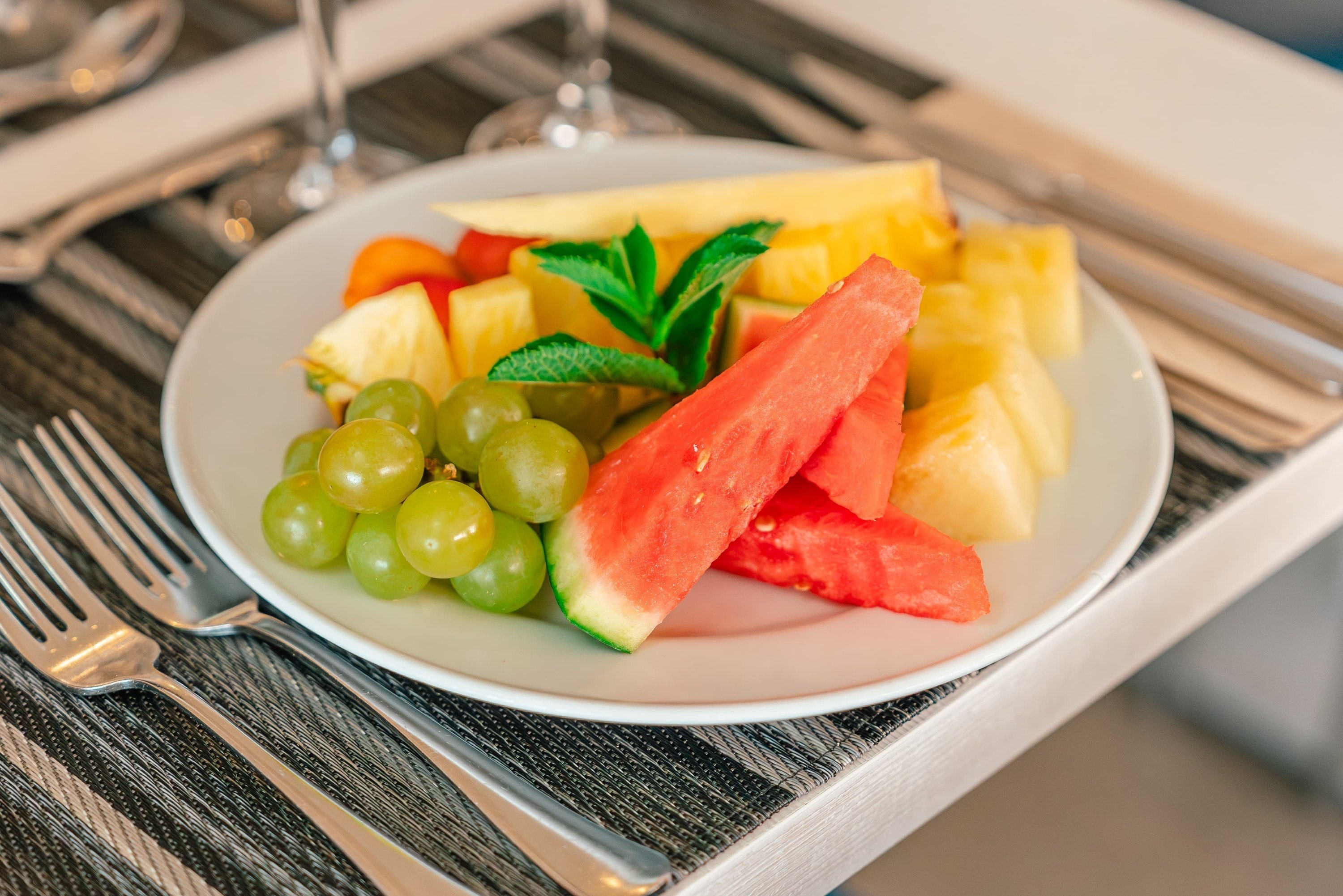 un plato de frutas y verduras en una mesa con tenedor y cuchillo