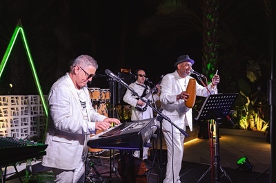 a man in a white suit is playing a keyboard - 