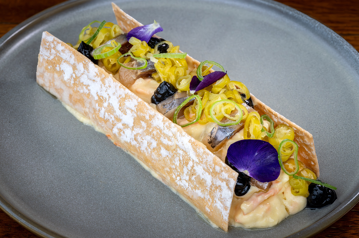 un plato de comida con una flor morada encima
