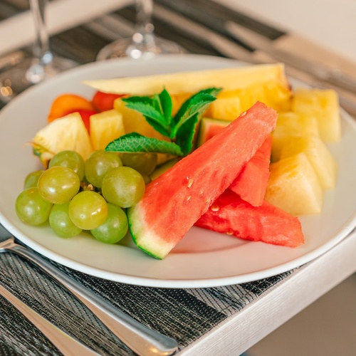 un plato de frutas y verduras en una mesa con tenedor y cuchillo