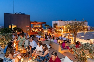 un grupo de personas están sentadas en una terraza al aire libre - 