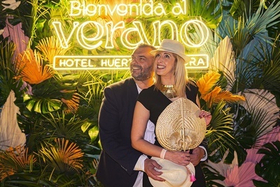 a man and woman pose in front of a sign that says hotel huer - 