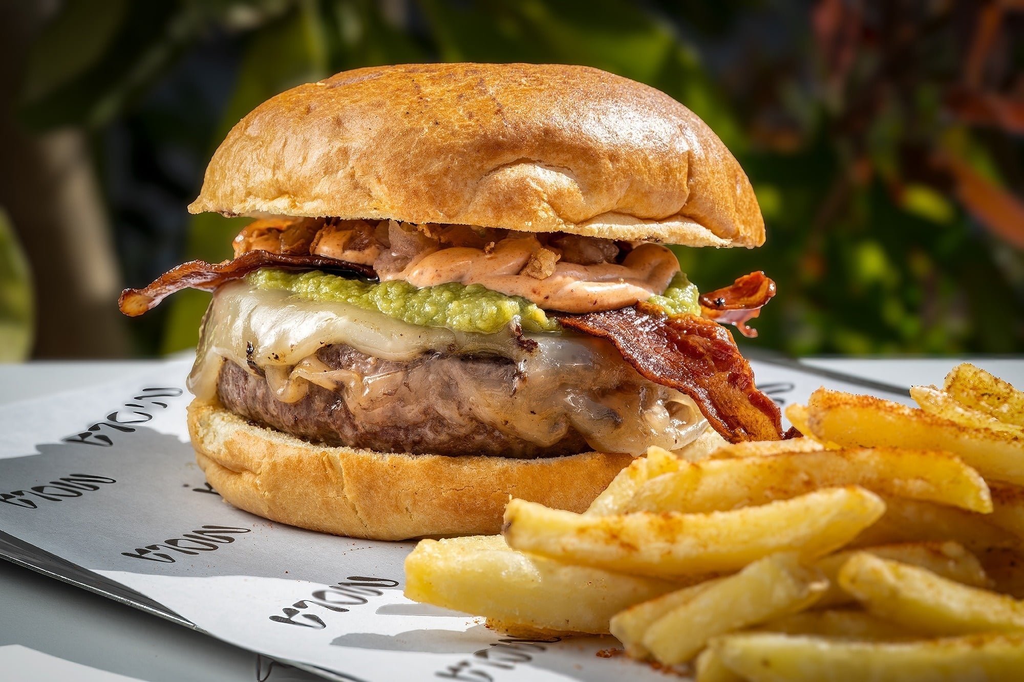 una hamburguesa y papas fritas están envueltos en papel mola