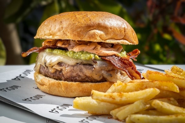 una hamburguesa y papas fritas están envueltos en papel mola