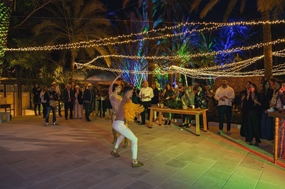 a group of people are gathered under a string of lights - 