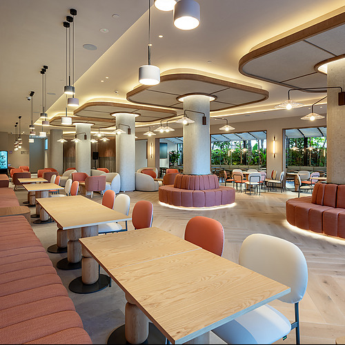 Port Hotels: Corporativa: Comedor moderno en hotel con sofás curvos y mesas de madera.