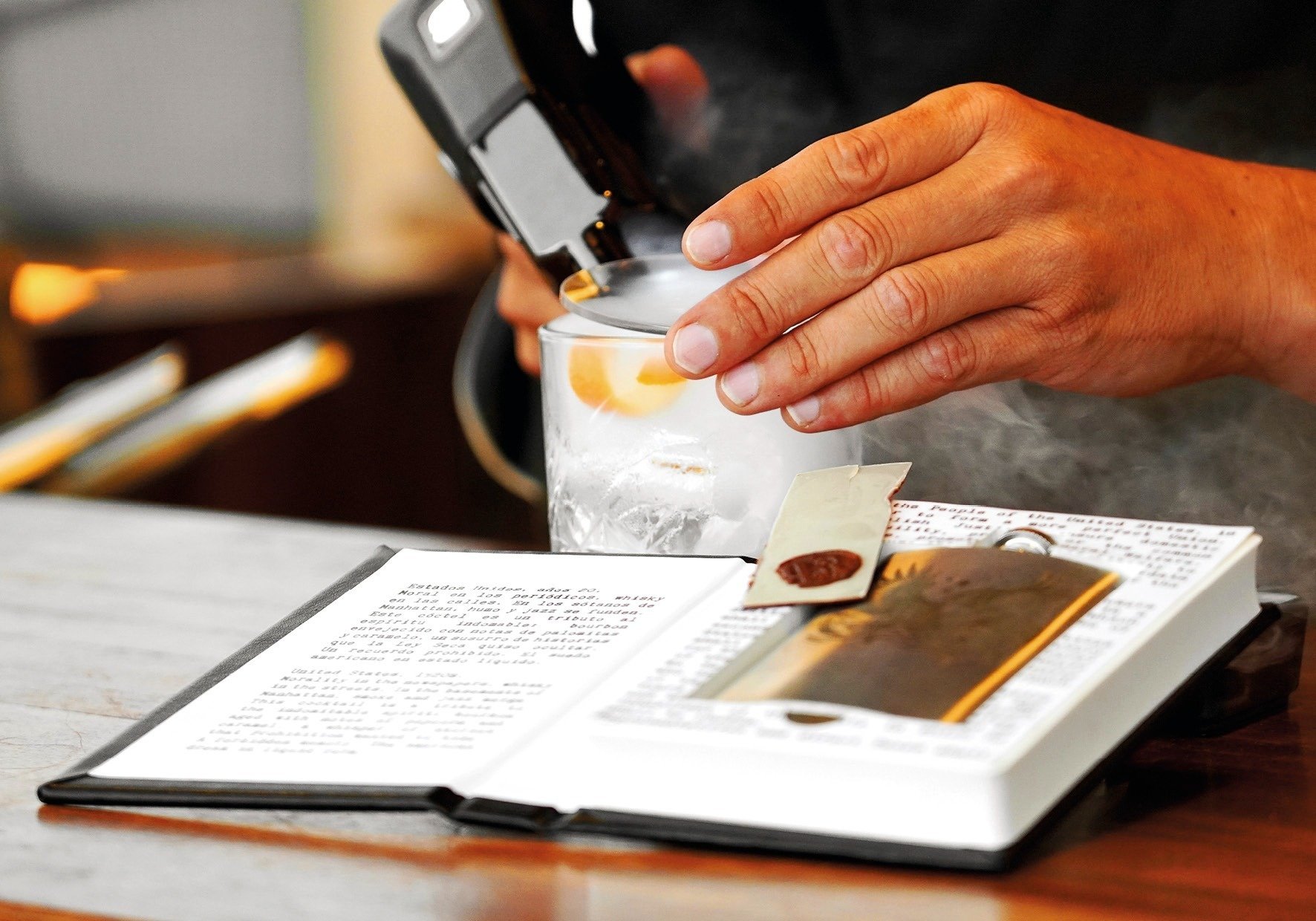 a person is pouring liquid into a glass while holding a cell phone