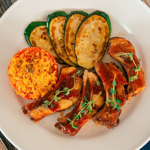 a white plate with meat and vegetables on it