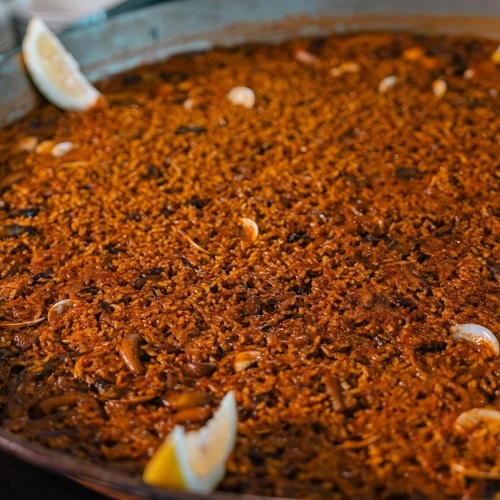 a pan of rice with lemon slices on top