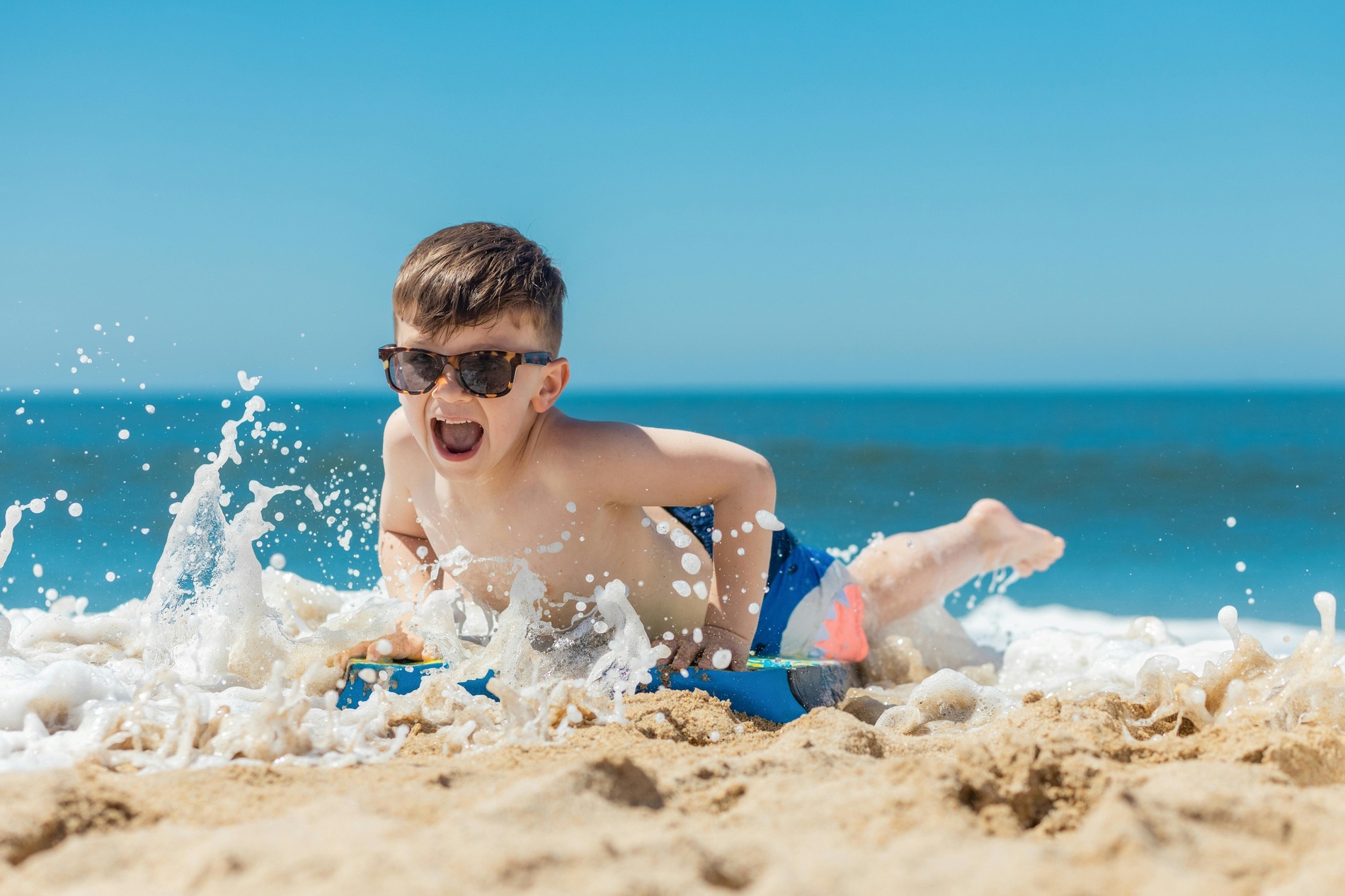 a family splashing in the ocean on a sunny day