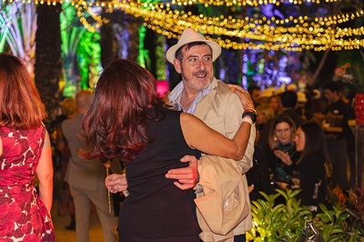 a man in a hat is hugging a woman at a party - 