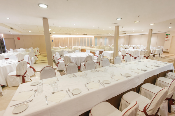 una sala de conferencias con mesas y sillas y una pantalla