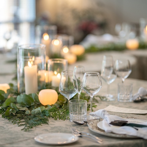 a table setting with candles and glasses on it