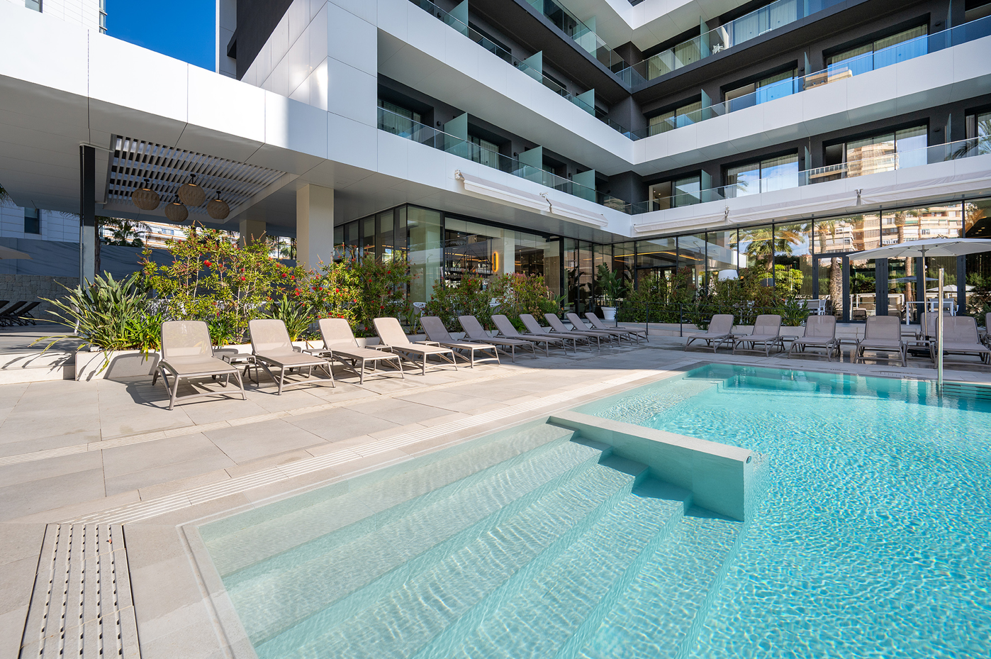 una piscina rodeada de sillas y escaleras en un hotel