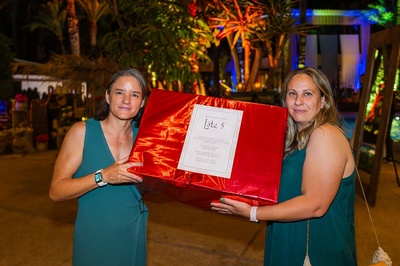 dos mujeres sostienen una caja roja que dice lotes 5 - 