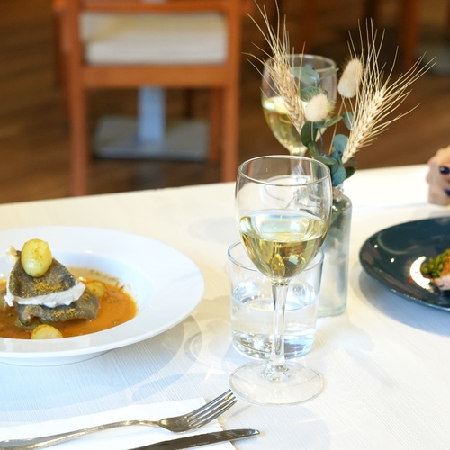 two plates of food and two glasses of wine on a table