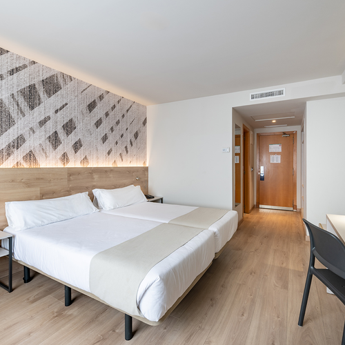 una habitación de hotel con dos camas y una televisión