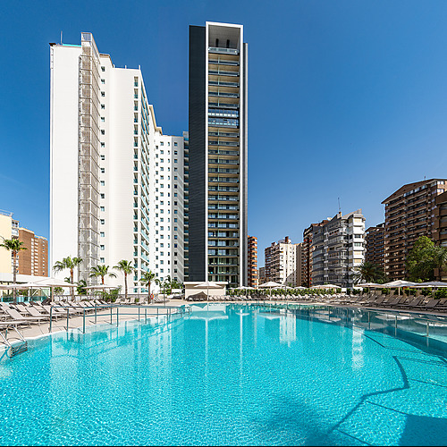 Piscina del hotel con tumbonas y rascacielos, ideal para Port Hotels: Corporativa y relajarse.