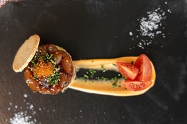 un plato de comida con tomates y una galleta encima