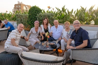 a group of people sitting around a table with champagne glasses - 