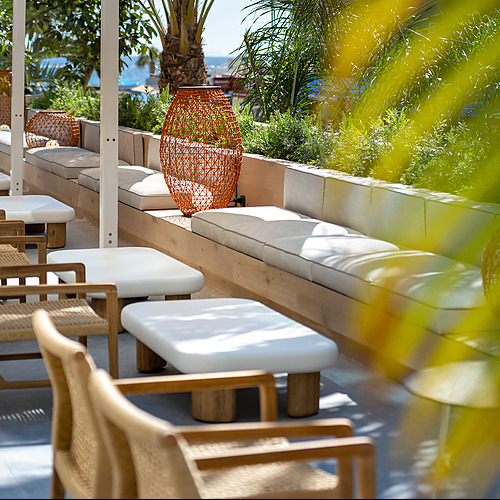 Terraza de hotel con asientos cómodos y estilo tropical Port Hotels: Corporativa.