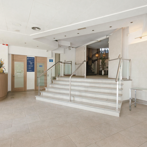a lobby with stairs and a sign that says ' hotel ' on it