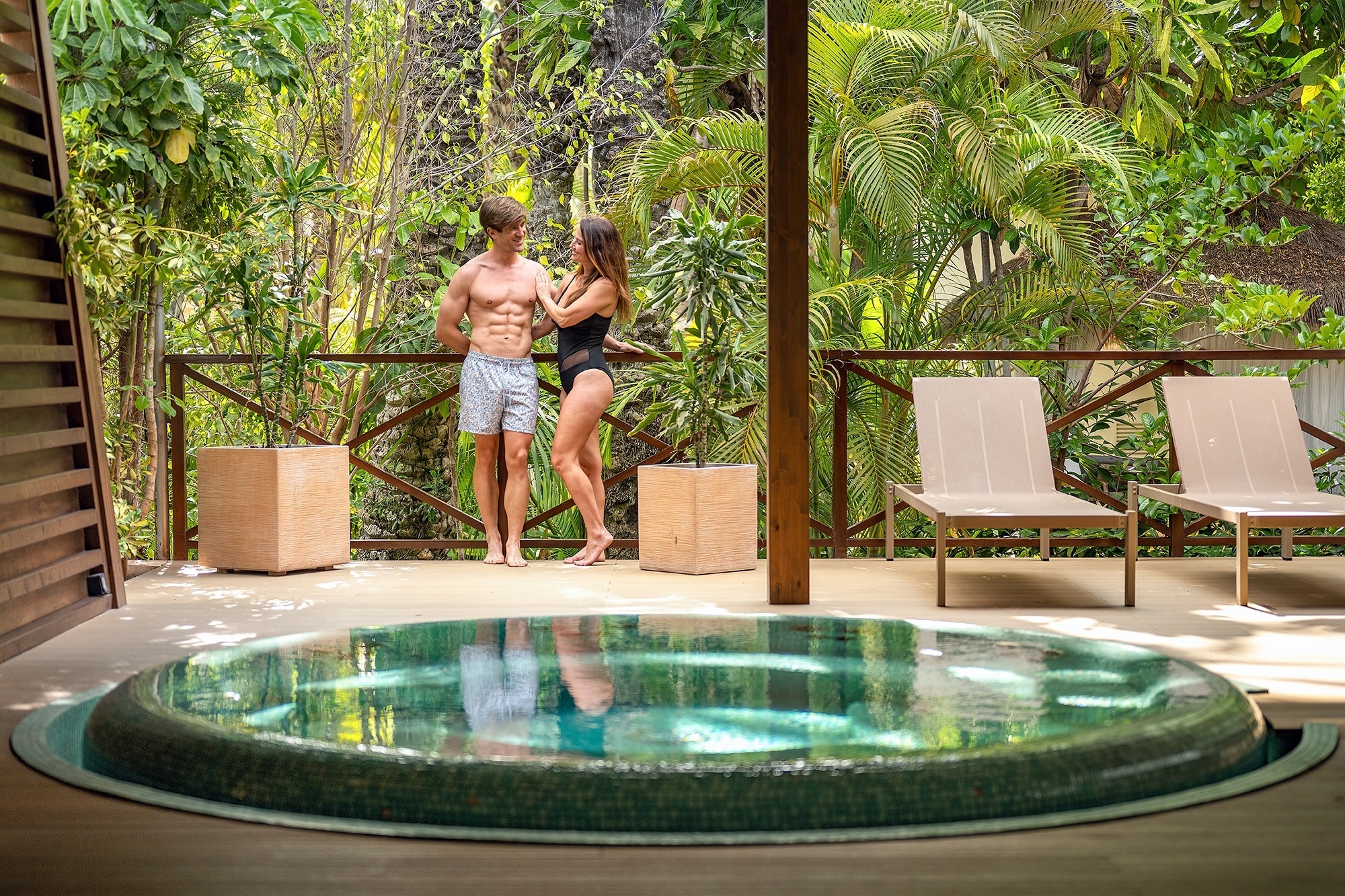 a hot tub is surrounded by lounge chairs under a wooden roof