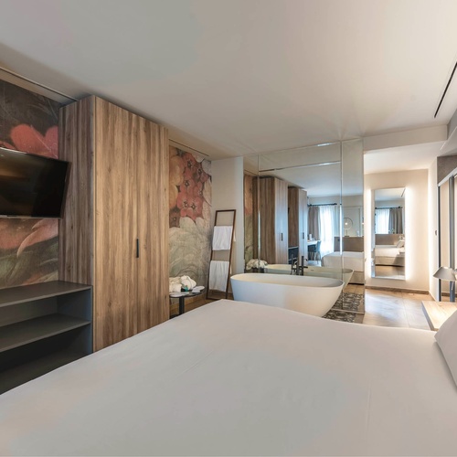 a hotel room with a large bed and a bathtub