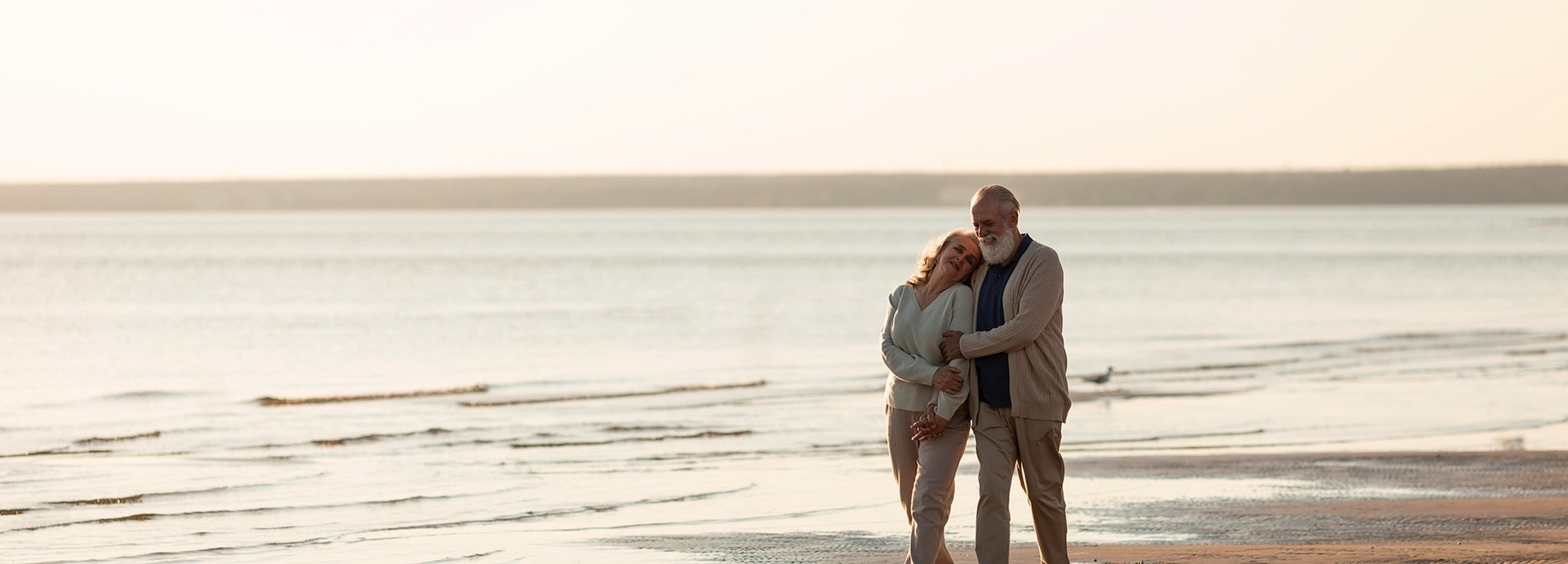 a man and a woman are walking on the beach