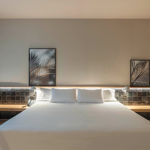 a hotel room with a king size bed and a chair