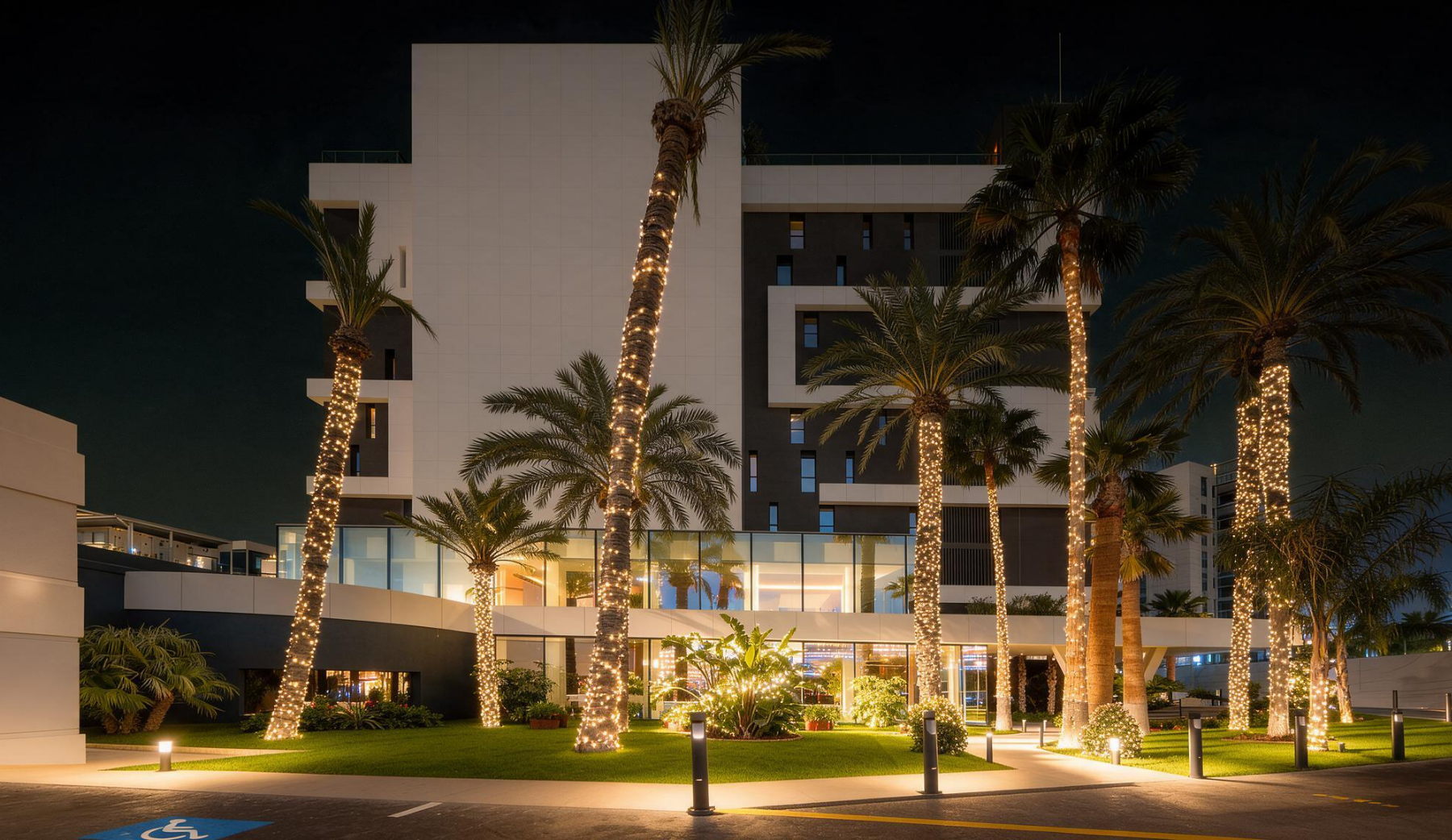 Entrada Port Hotels: Corporativa com luzes festivas e vegetação exuberante.