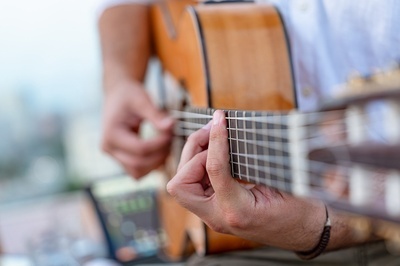 a close up of a person playing an acoustic guitar - 