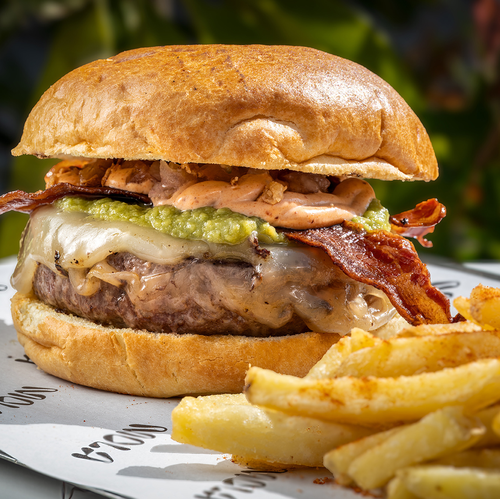 un primer plano de una hamburguesa y papas fritas en una mesa