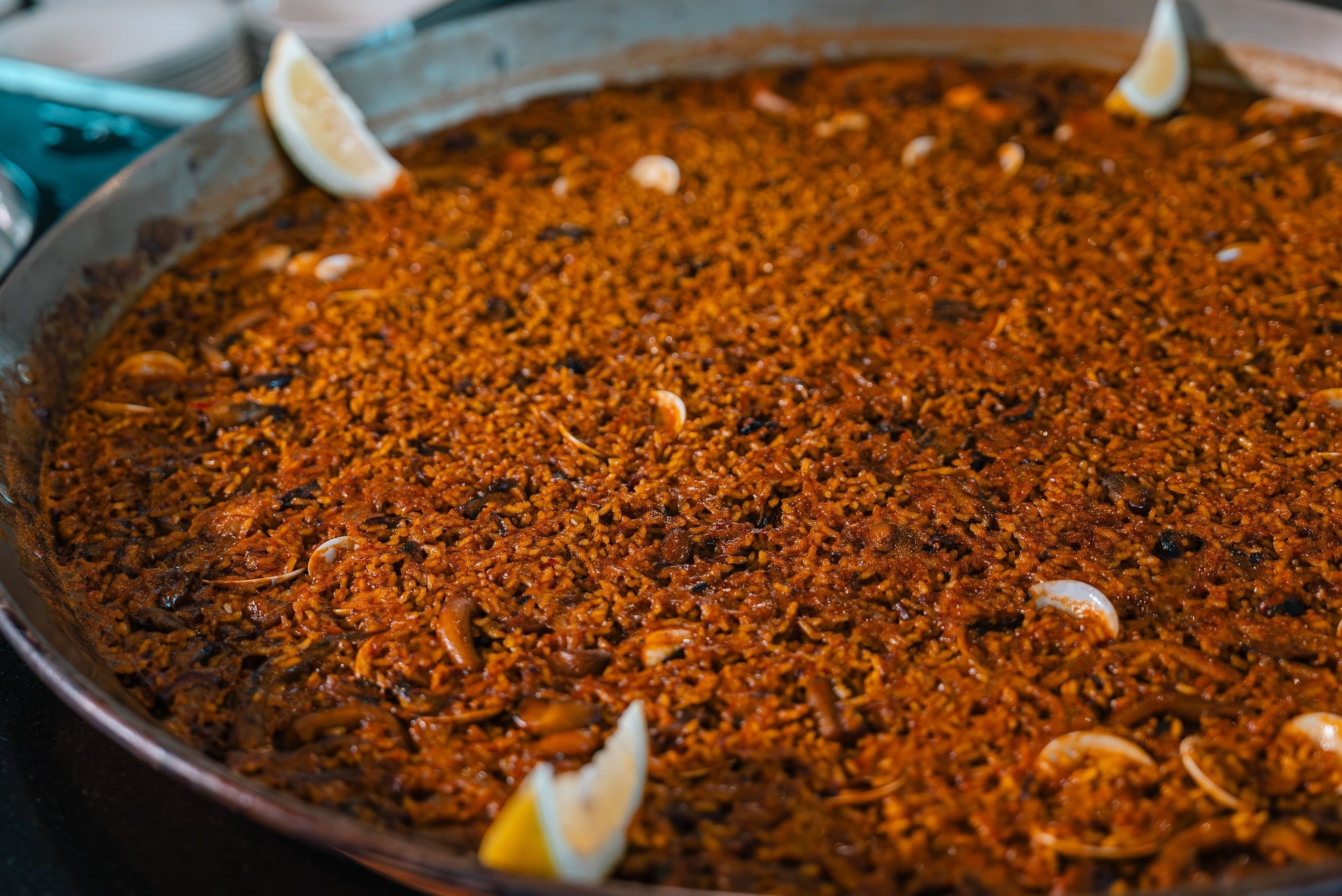 una sartén llena de arroz y camarones con rodajas de limón