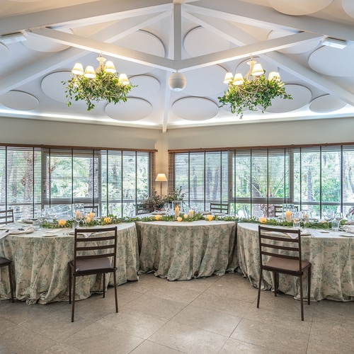 a room with tables and chairs and a chandelier hanging from the ceiling
