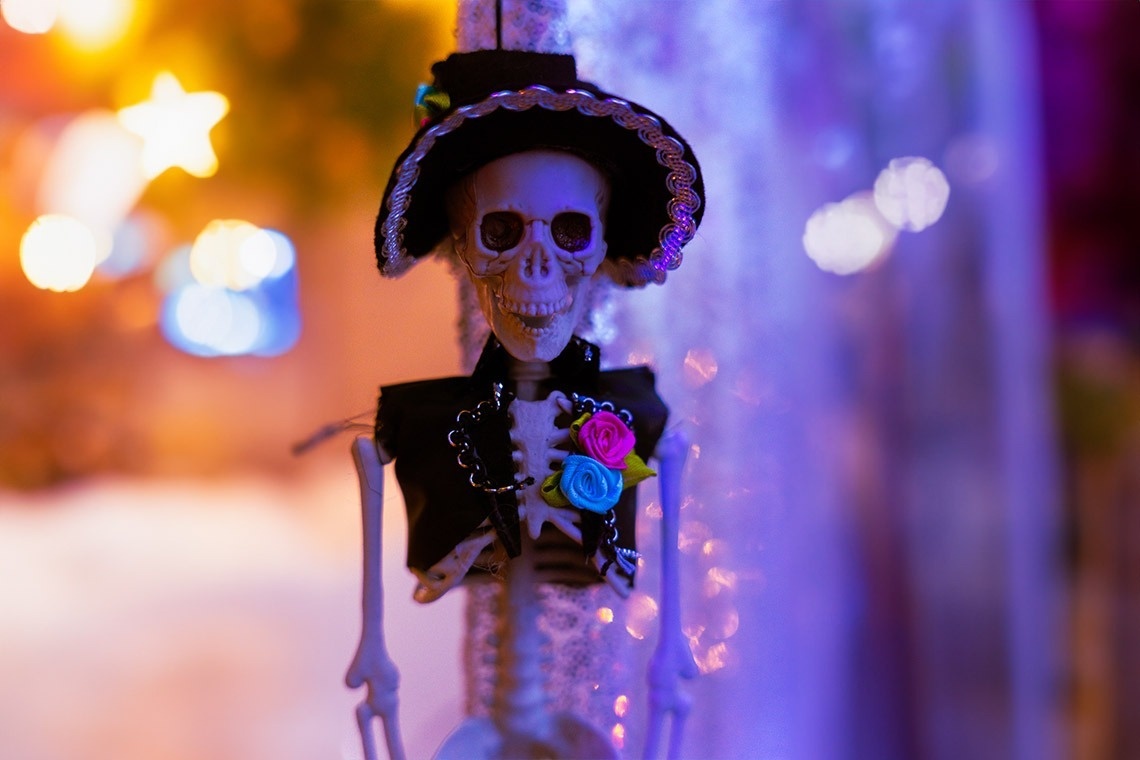 a skeleton wearing a black top hat and a black vest