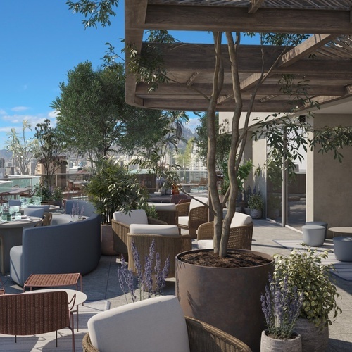 una terraza llena de muebles y plantas con vistas al océano