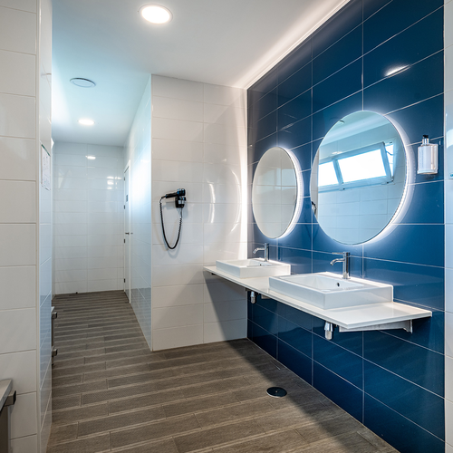 un baño azul y blanco con dos lavabos y dos espejos