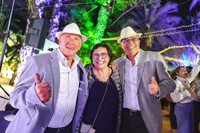 three people posing for a picture and one of them is giving a thumbs up - 