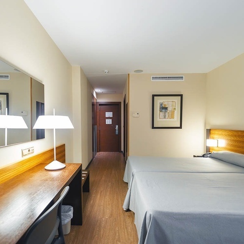 una habitación de hotel con dos camas y un escritorio