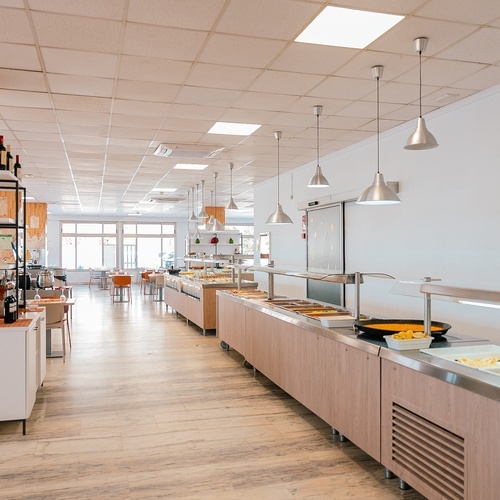 a buffet line in a restaurant with bottles of wine on the shelves