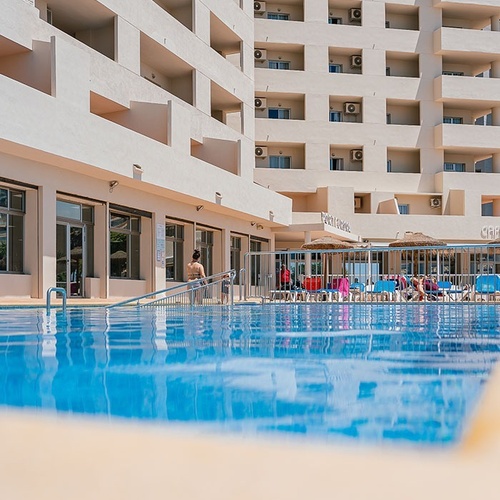 a large building with a swimming pool in front of it