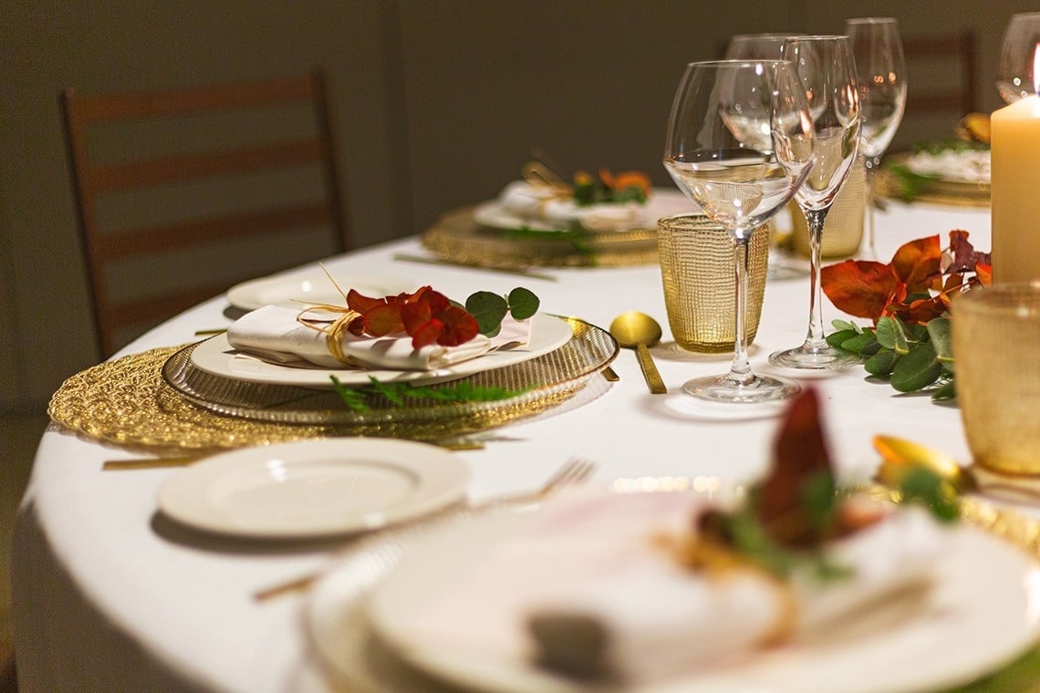 a table set for a dinner with plates and glasses