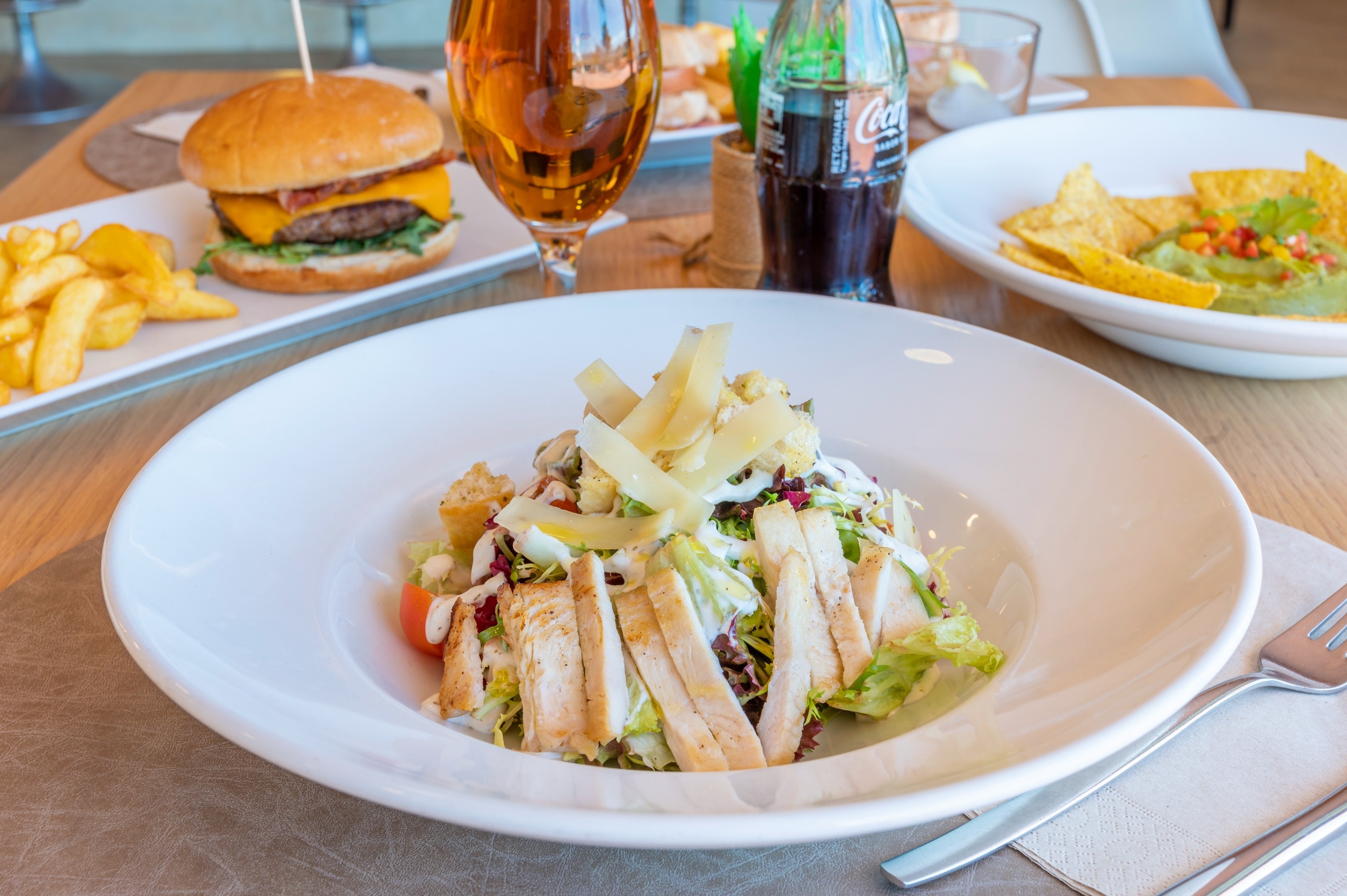 a bottle of coca cola sits next to a plate of food