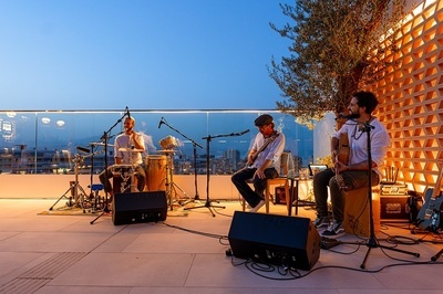 un hombre toca un saxofón mientras dos hombres tocan instrumentos musicales - 